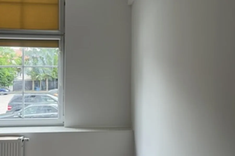 Jasne wykończone wnętrze z oknem po modernizacji w Chojnicach