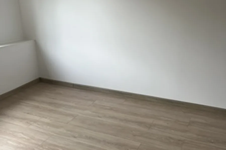 Odnowione pomieszczenie z jasnymi ścianami i nową podłogą w Chojnicach